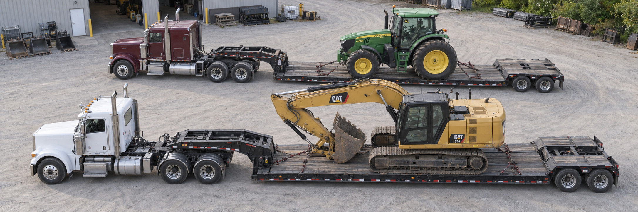 Elevated view of CAT and John Deere equipment secured on transport trailers